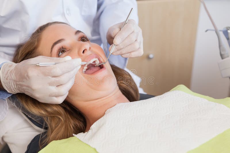 Dentysty egzamininować pacjentów zęby w dentysty krześle zdjęcie stock Dentysty egzamininować pacjentów zęby w dentysty krześle zdjęcie stock