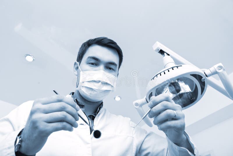 Dentysty egzamininować pacjentów zęby w dentysty krześle obraz stock Dentysty egzamininować pacjentów zęby w dentysty krześle obraz stock