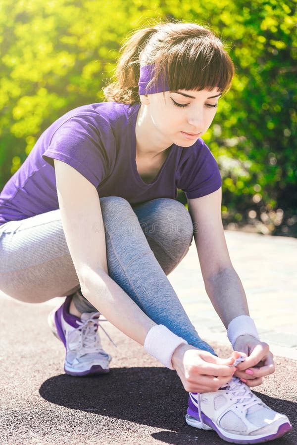 Deporte, aptitud, gente y concepto de la forma de vida - cercano para arriba de la mujer que ata cordones al aire libre fotografía de archivo Deporte, aptitud, gente y concepto de la forma de vida - cercano para arriba de la mujer que ata cordones al aire libre fotografía de archivo