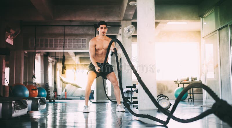 Deportista con cuerdas de batalla haciendo ejercicio en el gimnasio Fitness, gimnasia, deporte, cuerda, entrenamiento, atleta, en imágenes de archivo libres de regalías Deportista con cuerdas de batalla haciendo ejercicio en el gimnasio Fitness, gimnasia, deporte, cuerda, entrenamiento, atleta, en imágenes de archivo libres de regalías