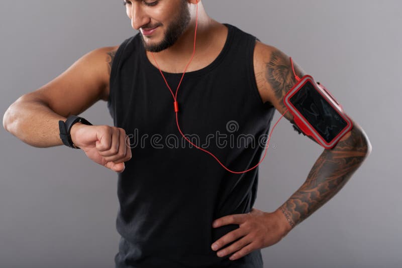Deportista con el teléfono y el smartwatch imagen de archivo libre de regalías Deportista con el teléfono y el smartwatch imagen de archivo libre de regalías