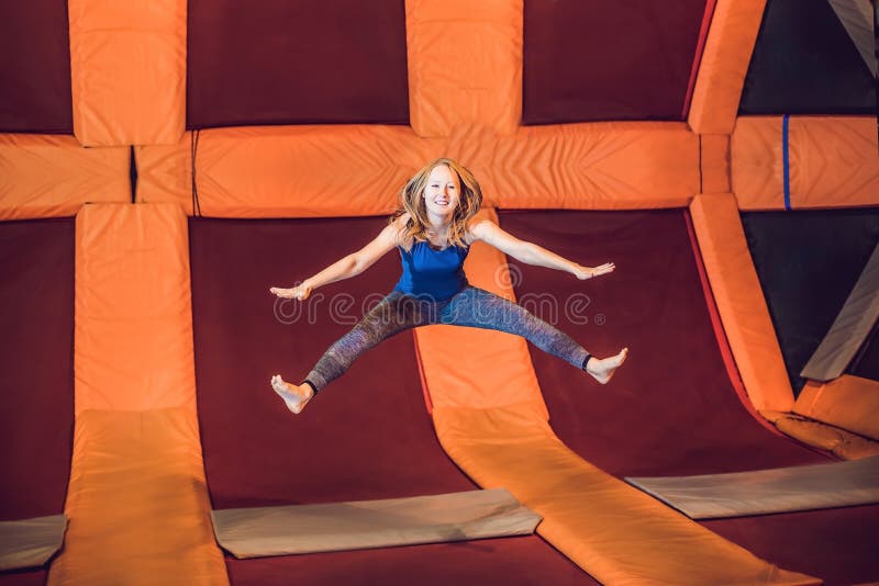 Deportista de la mujer joven saltando en un trampolín en el parque de la aptitud foto de archivo libre de regalías Deportista de la mujer joven saltando en un trampolín en el parque de la aptitud foto de archivo libre de regalías