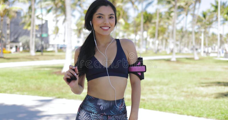 Deportista encantadora con los auriculares en parque
