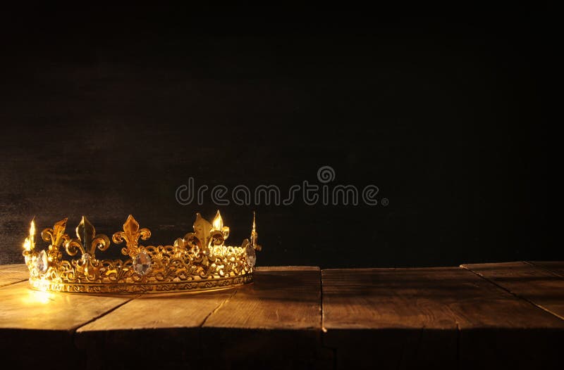 low key image of beautiful queen/king crown over wooden table. vintage filtered. fantasy medieval period. low key image of beautiful queen/king crown over wooden table. vintage filtered. fantasy medieval period