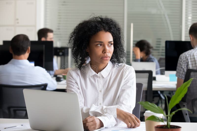 Depressed black woman distracted from work lost in thoughts