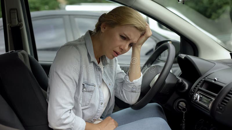 Depressed casual woman sitting in car, dissatisfied with her life, daily routine royalty free stock photography Depressed casual woman sitting in car, dissatisfied with her life, daily routine royalty free stock photography