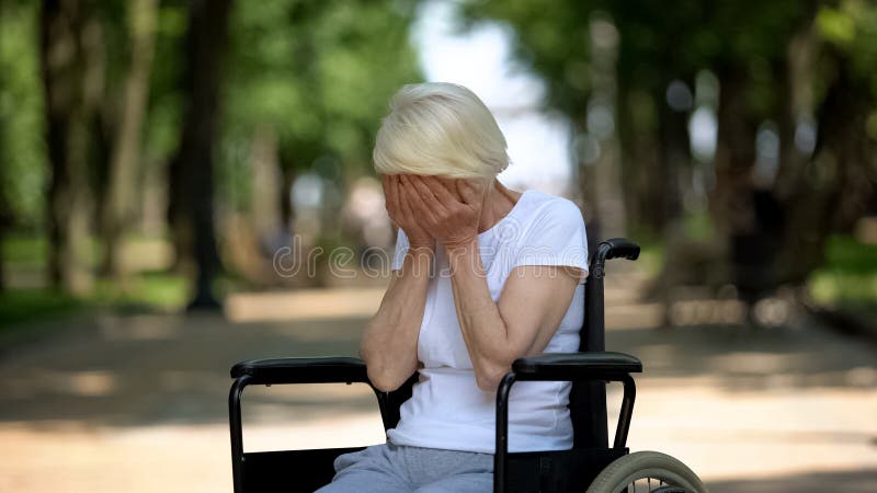 Depressed elderly female crying sitting in wheelchair at rehabilitation center royalty free stock image Depressed elderly female crying sitting in wheelchair at rehabilitation center royalty free stock image