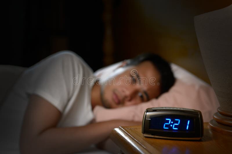 Depresso uomo soffre di insonnia, sdraiato nel letto.