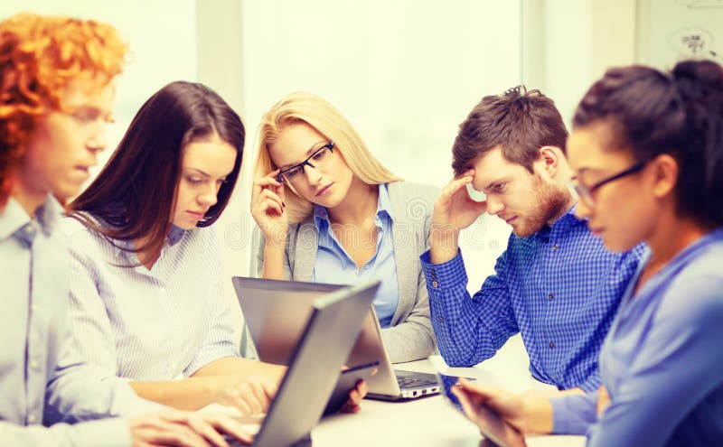 Depressed team with laptop and table pc computers stock photo