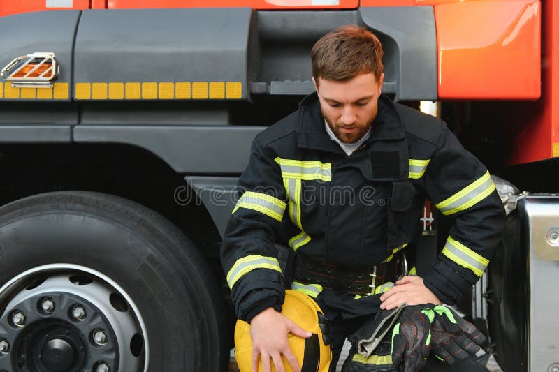 Depressed and tired firefighter near fire truck royalty free stock photography