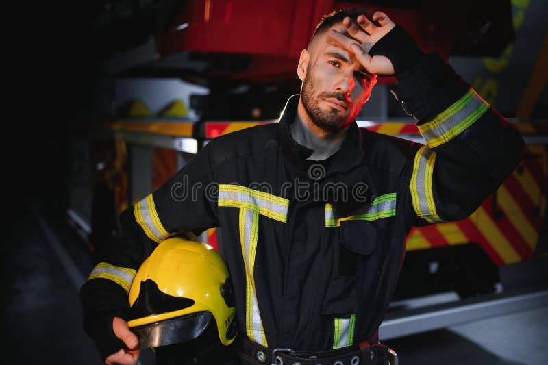 Depressed and tired firefighter near fire truck stock images