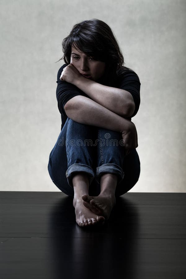 Depressed woman sitting on the floor stock image Depressed woman sitting on the floor stock image