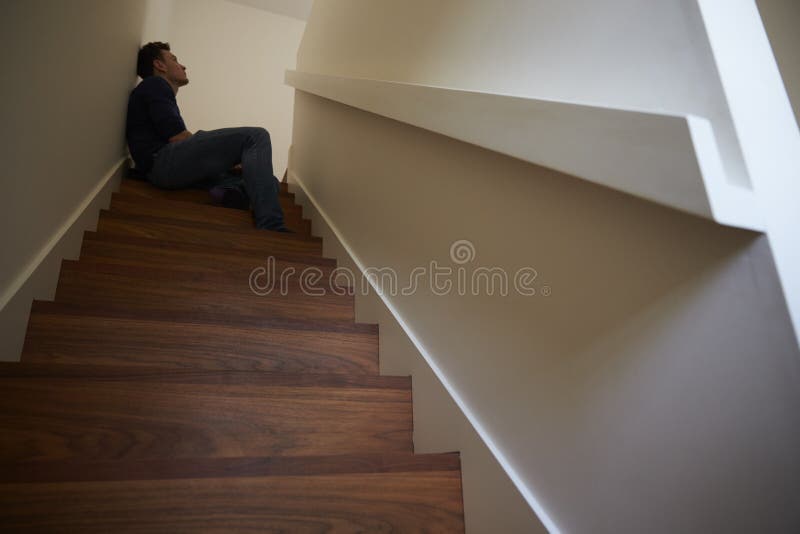 Depressed Young Man Sitting On Stairs At Home royalty free stock images Depressed Young Man Sitting On Stairs At Home royalty free stock images