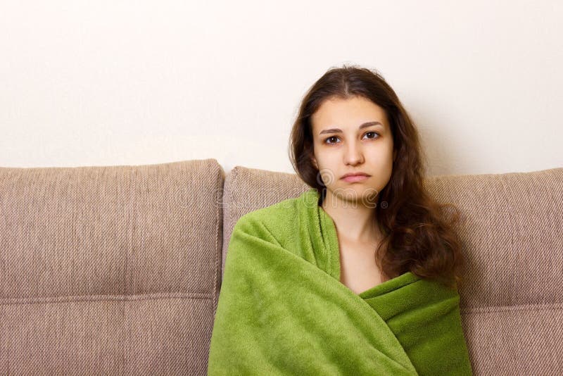 Depressed young woman sitting on sofa. Stressed and upset adolescent girl feels emotional emptiness, loneliness, worried because o royalty free stock photos Depressed young woman sitting on sofa. Stressed and upset adolescent girl feels emotional emptiness, loneliness, worried because o royalty free stock photos