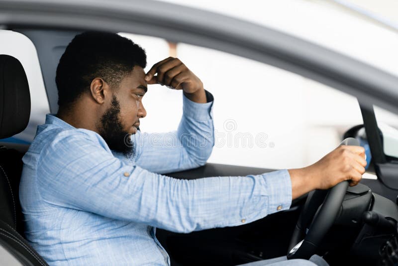 Depressieve man zit in de bestuurdersstoel van een te dure auto