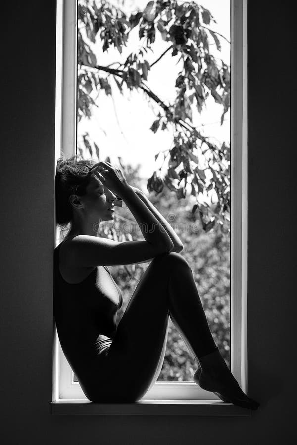 Depression apathy loneliness. lack of vitamins. pretty sporty woman on window royalty free stock image Depression apathy loneliness. lack of vitamins. pretty sporty woman on window royalty free stock image