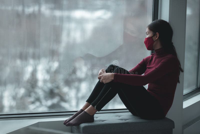 Depressão de inverno devido ao confinamento de coronavírus. mulher asiática triste sozinha durante o bloqueio da cidade usando más