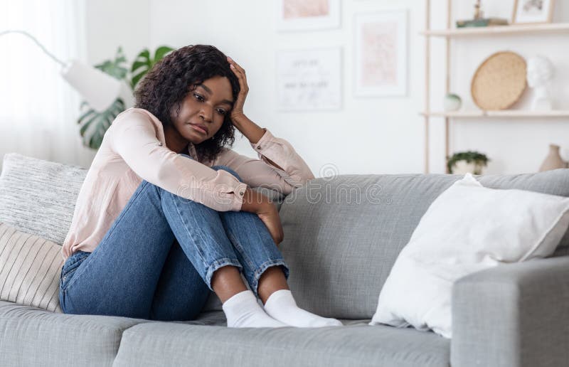 Depressão sazonal Mulher Negra Solitária Sentada No Sofá Com Expressão Triste Da Face