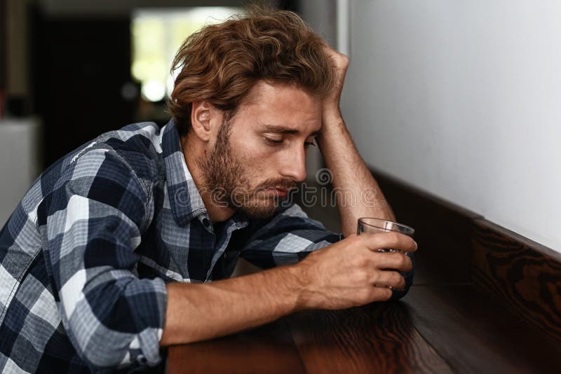 Deprimerad ung man som dricker alkohol i stång arkivfoton Deprimerad ung man som dricker alkohol i stång arkivfoton