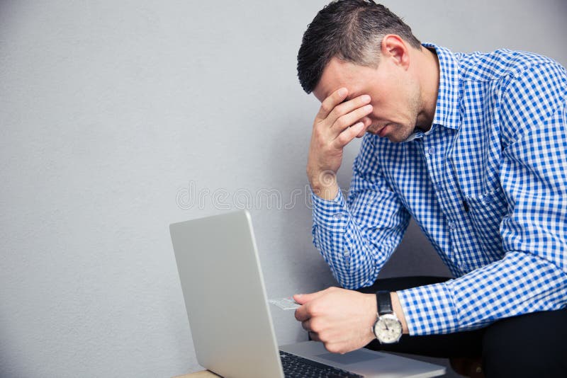 Deprimierter Mann, der Kreditkarte hält stockfotos Deprimierter Mann, der Kreditkarte hält stockfotos