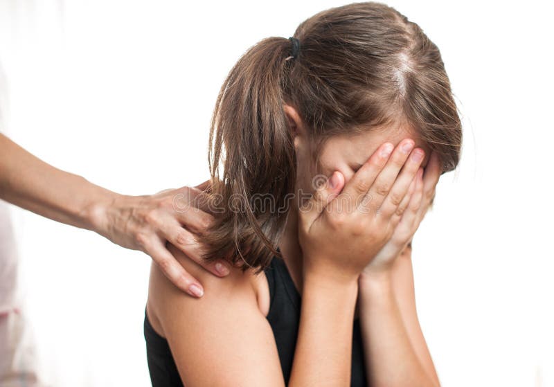 Depressed teenager sitting while hand coming from behind and offers support. Depressed teenager sitting while hand coming from behind and offers support.