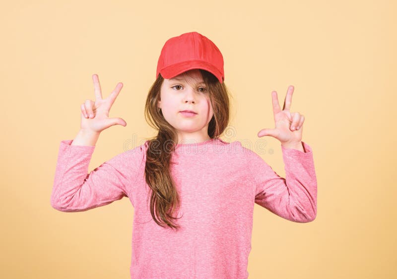 Der Abnutzungs-Kappe des Mädchens netter Kinderbeige Hintergrund oder des Hysteresenhutes. Mädchen, das Licht Baseballmütze trägt. lizenzfreie stockbilder