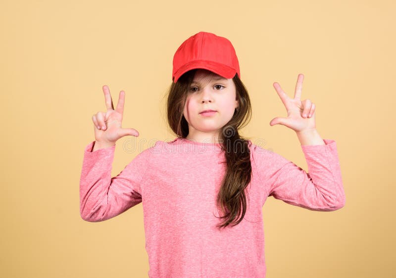Der Abnutzungs-Kappe des M? dchens netter Kinderbeige Hintergrund oder des Hysteresenhutes Wenig M? dchen, das helle Baseballm? tze stockbilder