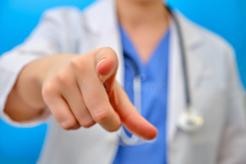 Der Arzt wird seinen Finger nach vorn auf Sie, Nahaufnahme auf einem blauen Hintergrund Die Krankenschwester gestikuliert mit ihr lizenzfreies stockbild
