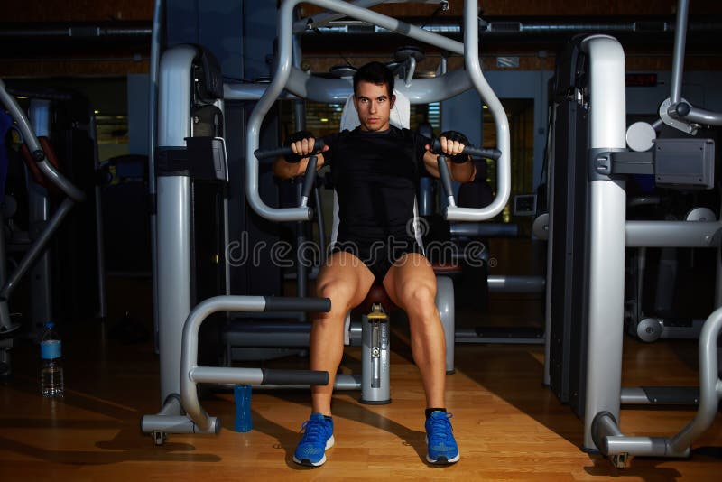 Der athletische junge Mann, der Kasten biegt, mischt auf Pressemaschine mit lizenzfreie stockbilder Der athletische junge Mann, der Kasten biegt, mischt auf Pressemaschine mit lizenzfreie stockbilder