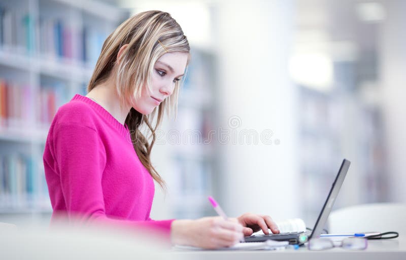 In der Bibliothek - hübscher weiblicher Kursteilnehmer lizenzfreies stockbild