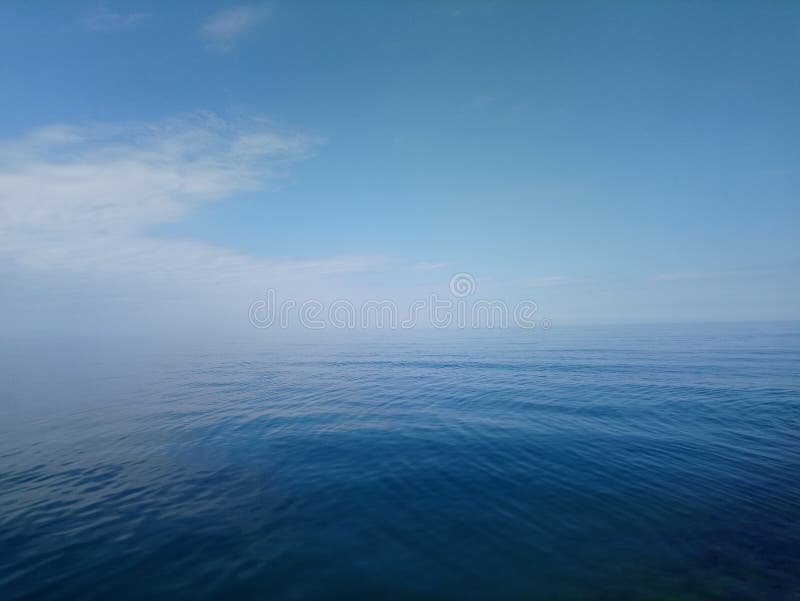 Der blaue Seehorizont mit Himmel in den Wolken. Das blaue Meer lässt den milde blauen Himmel mit den Wolken.