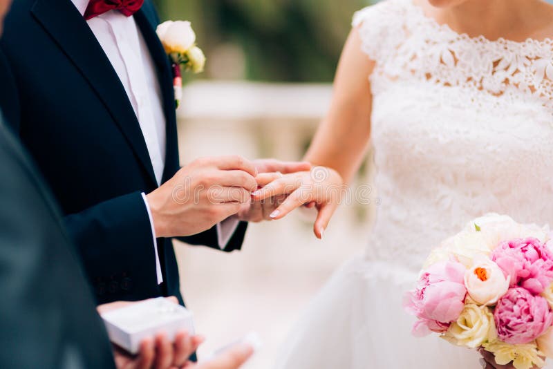 Der Bräutigam kleidet einen Ring auf dem Finger der Braut an einer Hochzeit lizenzfreies stockfoto Der Bräutigam kleidet einen Ring auf dem Finger der Braut an einer Hochzeit lizenzfreies stockfoto