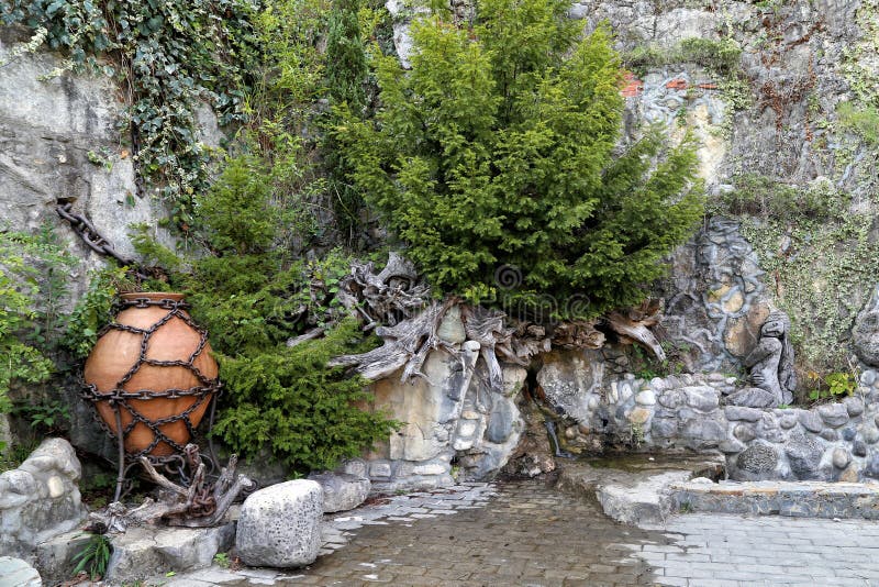 Der dekorative Entwurf des Felsens nahe dem Wasserfall im Stadtzentrum lizenzfreie stockfotografie Der dekorative Entwurf des Felsens nahe dem Wasserfall im Stadtzentrum lizenzfreie stockfotografie