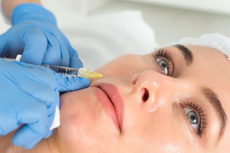 Der Doktor Cosmetologist macht das verjüngende Gesichtseinspritzungsverfahren für das Festziehen und das Glatt machen von Falten lizenzfreies stockbild Der Doktor Cosmetologist macht das verjüngende Gesichtseinspritzungsverfahren für das Festziehen und das Glatt machen von Falten lizenzfreies stockbild