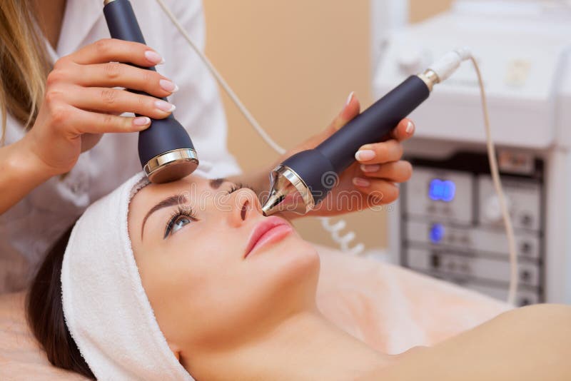 Der DoktorCosmetologist macht das Verfahren eine Ultraschallreinigung von der Gesichtshaut einer schönen, jungen Frau stockfoto Der DoktorCosmetologist macht das Verfahren eine Ultraschallreinigung von der Gesichtshaut einer schönen, jungen Frau stockfoto
