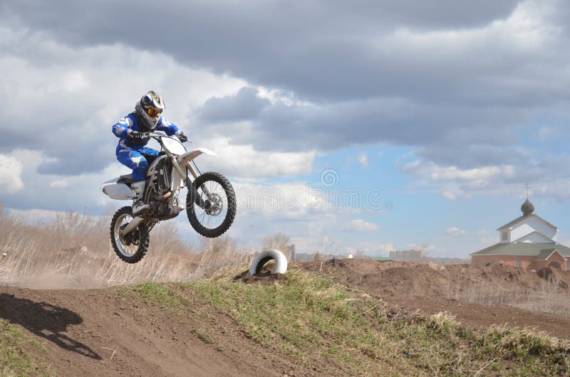 Der Fahrer, der auf dem MX-Motorrad steht, fliegt über lizenzfreie stockfotografie Der Fahrer, der auf dem MX-Motorrad steht, fliegt über lizenzfreie stockfotografie