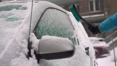 Der Fahrer Räumt Das Auto Mit Einer Bürste Vom Schnee Ab. Ein Auto