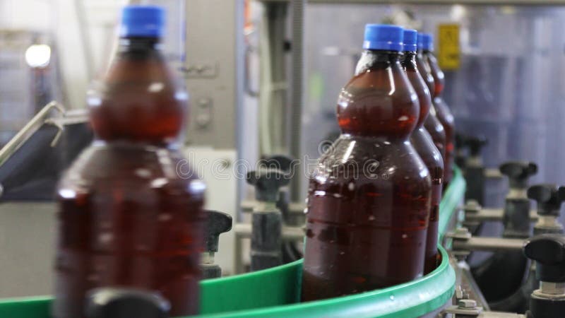 Der Fluss von Plastikflaschen gefüllt mit Bierbewegungen auf dem Förderband