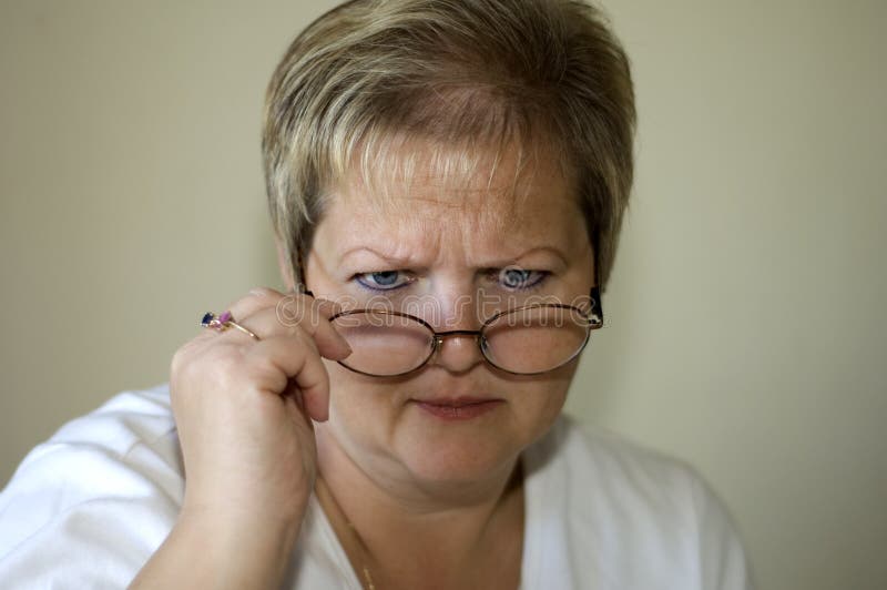 Blond woman with glare look over eyeglasses. Blond woman with glare look over eyeglasses