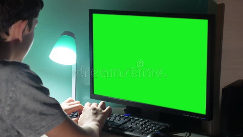 Der grüne des Schlüssels Teenager zuhause, der Computernahaufnahme spielt, übergibt das Spielvideo, das zurück sitzt Junge Innens