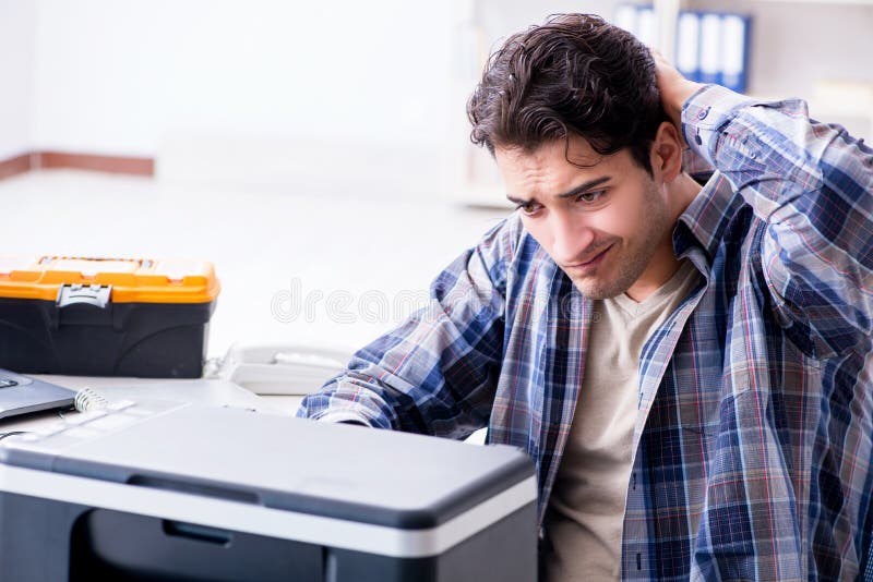 Hardware repairman repairing broken printer fax machine. Hardware repairman repairing broken printer fax machine