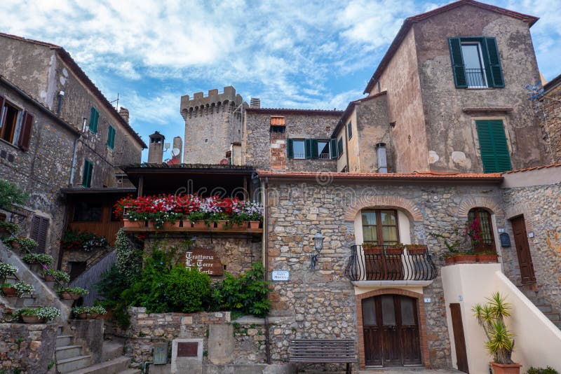 Der Hauptplatz weniger mittelalterlicher Stadt von Capalbio, Toskana, Italien, mit Gebäuden und Blumen lizenzfreie stockfotos Der Hauptplatz weniger mittelalterlicher Stadt von Capalbio, Toskana, Italien, mit Gebäuden und Blumen lizenzfreie stockfotos