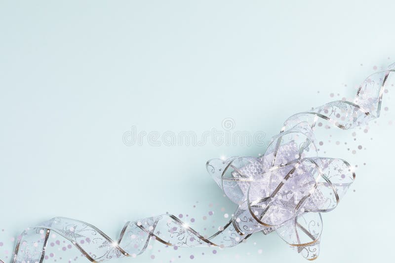 Der Hintergrund Grußkarte mit festlich silberglänzendem Band mit Bowknot auf der Geschenkbox auf hellblau stockfotografie Der Hintergrund Grußkarte mit festlich silberglänzendem Band mit Bowknot auf der Geschenkbox auf hellblau stockfotografie
