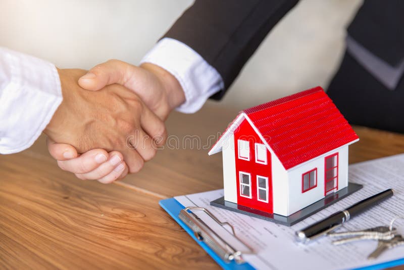 Der Immobilienmakler, der H?nde mit dem Kunden nach Vertragsunterzeichnung, Gesch?ft ein Vertragskauf-verkaufshaus unterzeichnend
