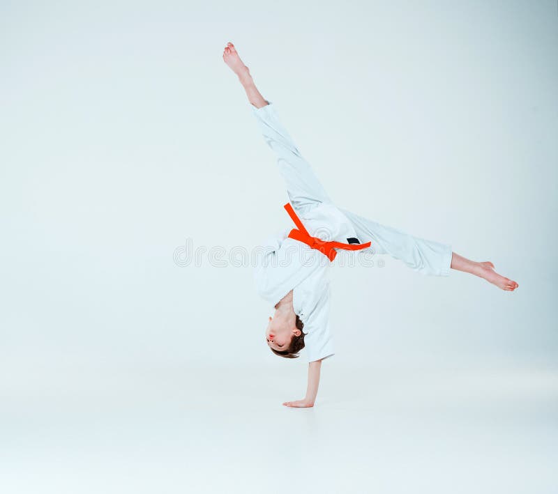 Der Junge, der am Aikidotraining in der Kampfkunstschule aufwirft Gesunder Lebensstil und Sportkonzept lizenzfreie stockfotos Der Junge, der am Aikidotraining in der Kampfkunstschule aufwirft Gesunder Lebensstil und Sportkonzept lizenzfreie stockfotos