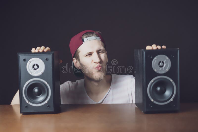 Der junge audiophile Mann hören laute Musik von Sprechern f lizenzfreie stockfotos Der junge audiophile Mann hören laute Musik von Sprechern f lizenzfreie stockfotos