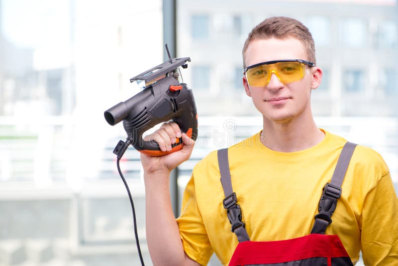Der junge Bauarbeiter im gelben Overall lizenzfreie stockfotografie Der junge Bauarbeiter im gelben Overall lizenzfreie stockfotografie