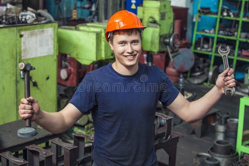 Der junge Mann, der an der alten Fabrik auf Installation von equi arbeitet stockbild Der junge Mann, der an der alten Fabrik auf Installation von equi arbeitet stockbild