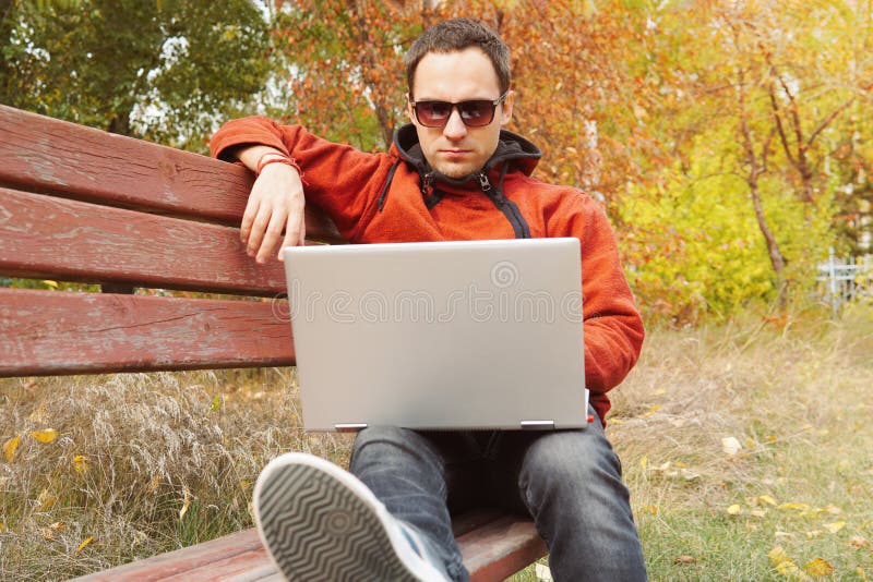 Der junge Mann, der an seinem Laptop arbeitet, schließen an drahtloses Internet im ländlichen Gebiet an Internetanschluss erlaubt lizenzfreies stockfoto Der junge Mann, der an seinem Laptop arbeitet, schließen an drahtloses Internet im ländlichen Gebiet an Internetanschluss erlaubt lizenzfreies stockfoto
