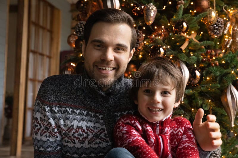Der junge Vater und der kleine Junge, der zu Weihnachten gratulierte. lizenzfreie stockbilder